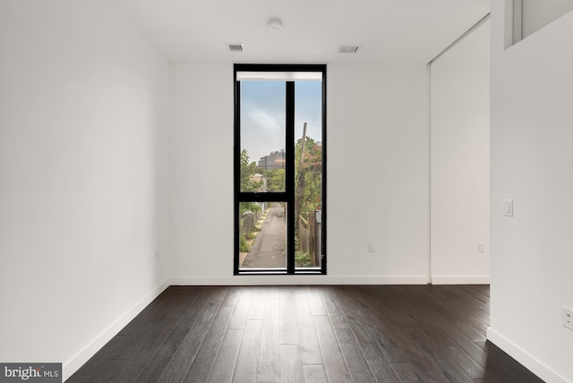 empty room with dark hardwood / wood-style flooring