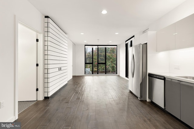 kitchen with white cabinetry, floor to ceiling windows, dark wood-type flooring, and stainless steel appliances