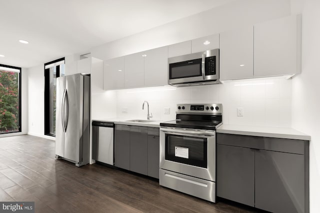 kitchen with white cabinets, sink, gray cabinetry, stainless steel appliances, and dark hardwood / wood-style flooring