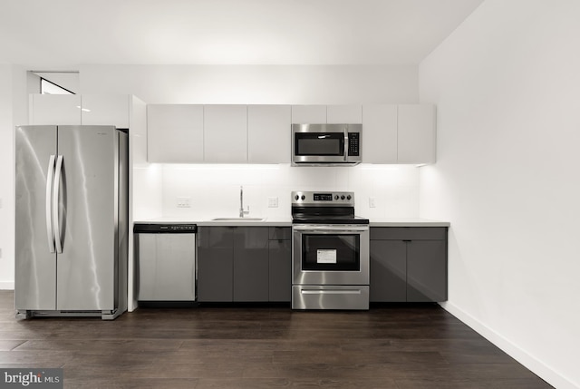 kitchen featuring stainless steel appliances, white cabinets, and dark wood-type flooring