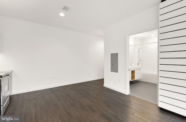 unfurnished bedroom with ensuite bath, electric panel, and dark wood-type flooring