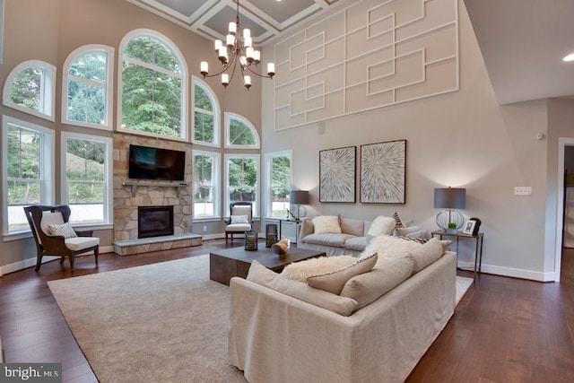 living room featuring a towering ceiling, dark hardwood / wood-style floors, and a healthy amount of sunlight