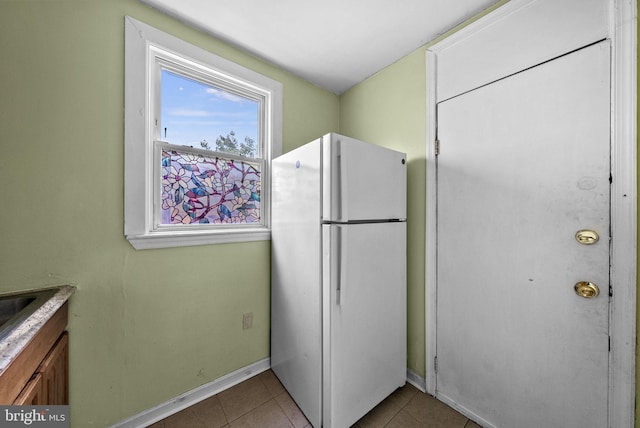 kitchen with light tile patterned flooring and white refrigerator