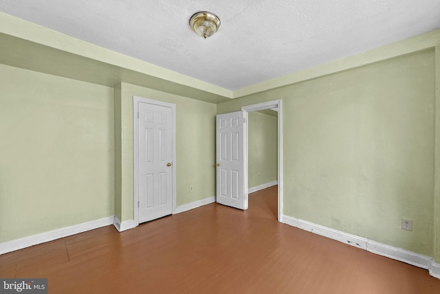 spare room featuring hardwood / wood-style floors and a textured ceiling