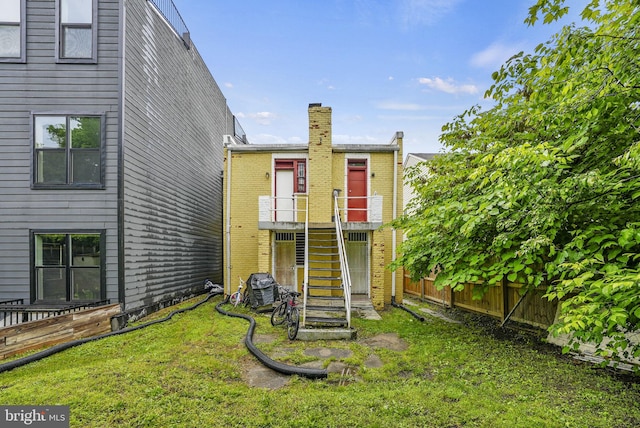 rear view of property featuring a lawn