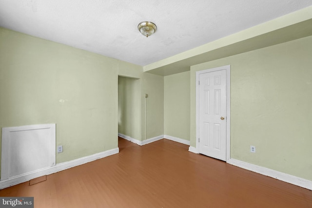 empty room featuring hardwood / wood-style flooring and a textured ceiling