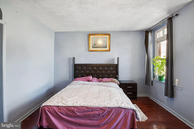 bedroom featuring dark hardwood / wood-style floors and a textured ceiling