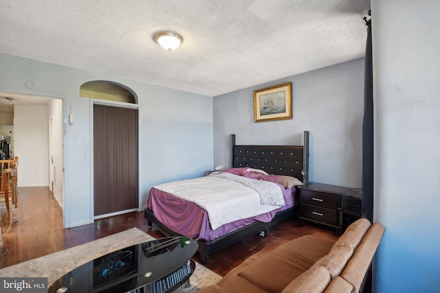 bedroom with dark hardwood / wood-style flooring and a textured ceiling