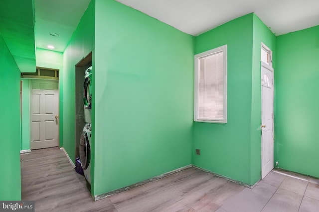 unfurnished room featuring stacked washer and dryer and light wood-type flooring