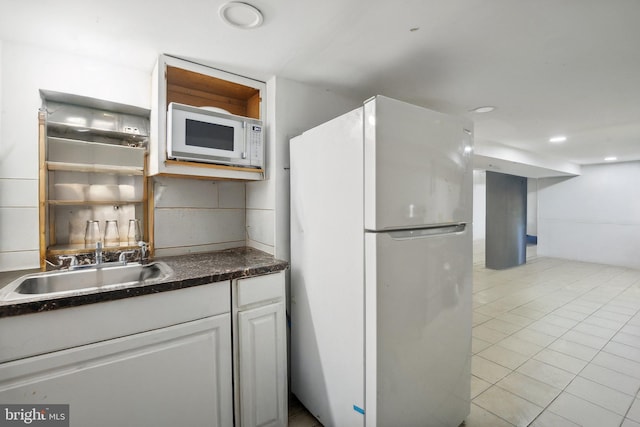 kitchen featuring light tile patterned flooring, sink, white appliances, and white cabinetry