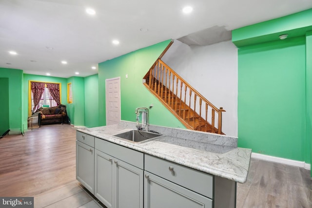 kitchen featuring gray cabinetry, sink, and light hardwood / wood-style flooring