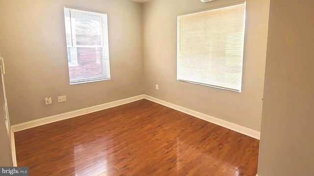 spare room featuring hardwood / wood-style flooring and a wealth of natural light