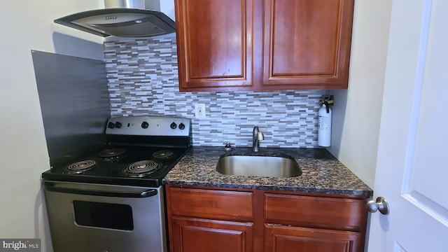 kitchen with decorative backsplash, dark stone counters, sink, electric range, and range hood