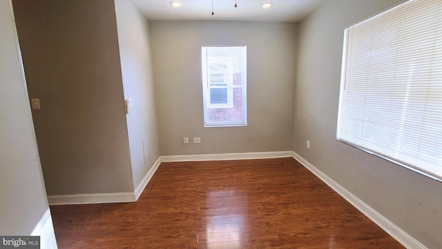 empty room with dark hardwood / wood-style flooring