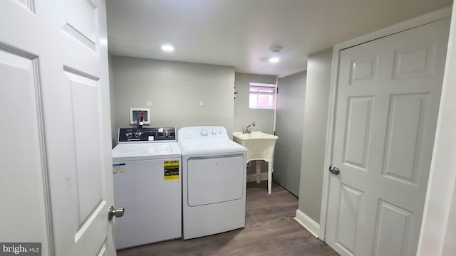 laundry room featuring washer and clothes dryer, dark hardwood / wood-style floors, and sink