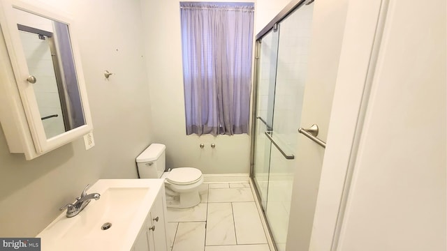 bathroom featuring vanity, a shower with shower door, and toilet