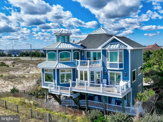 40110 Owens Ct, Fenwick Island, DE 19944 - rear view of house featuring fence, metal roof, a standing seam roof, and a balcony