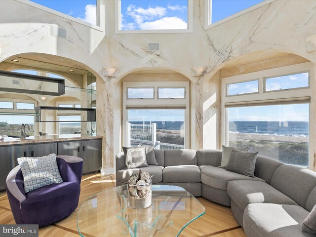 living room featuring a high ceiling, a water view, and a healthy amount of sunlight