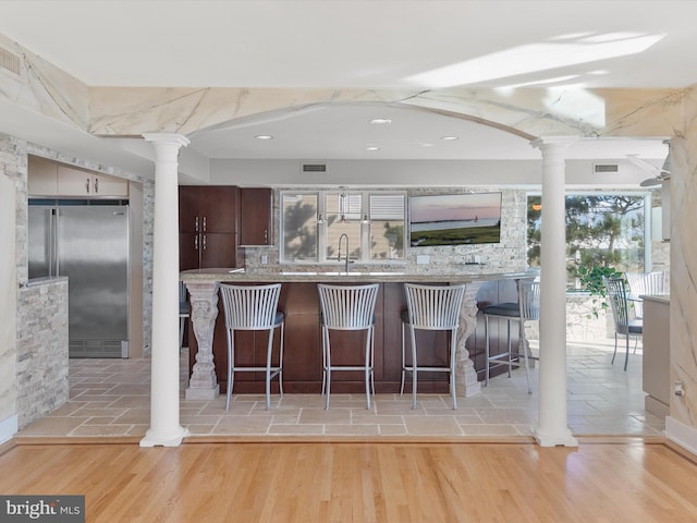 kitchen with light hardwood / wood-style floors, high end refrigerator, and a healthy amount of sunlight