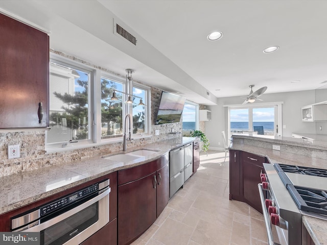 40110 Owens Ct, Fenwick Island, DE 19944 - kitchen with appliances with stainless steel finishes, light stone counters, visible vents, decorative backsplash, and a sink
