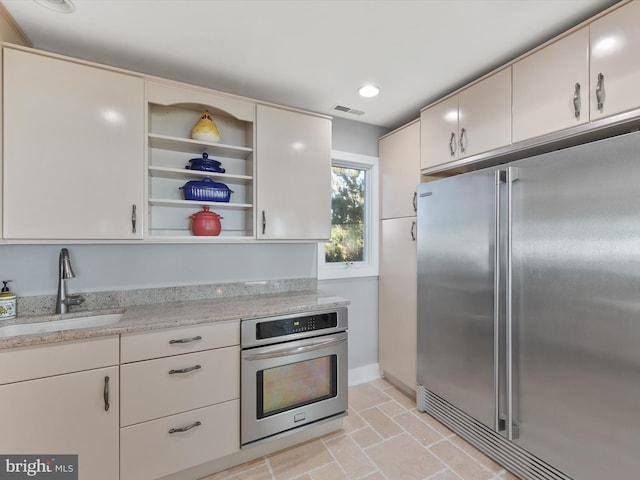 40110 Owens Ct, Fenwick Island, DE 19944 - kitchen with visible vents, baseboards, open shelves, a sink, and appliances with stainless steel finishes