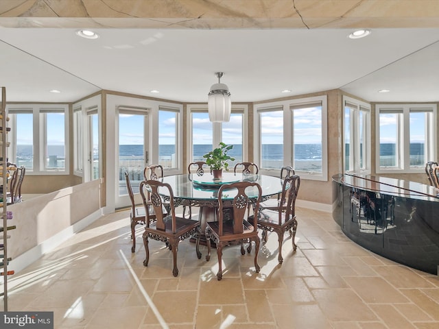 dining area featuring a water view and a wealth of natural light