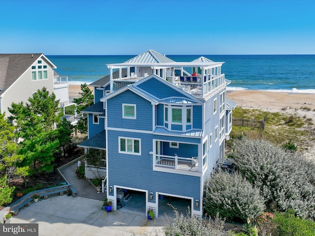 exterior space featuring a water view, a balcony, and a beach view