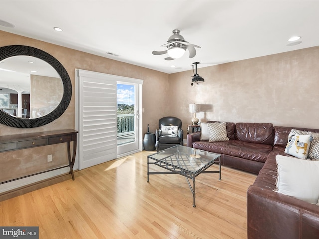 living room featuring ceiling fan and light hardwood / wood-style flooring