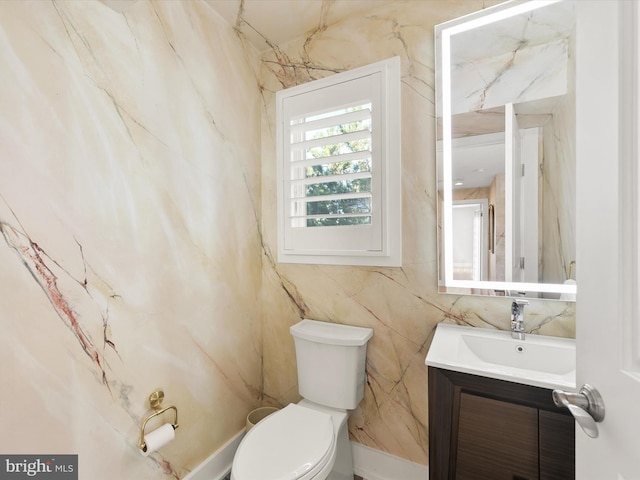 bathroom featuring tile walls, vanity, and toilet