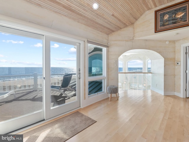 doorway featuring wood ceiling, vaulted ceiling, a water view, and a healthy amount of sunlight