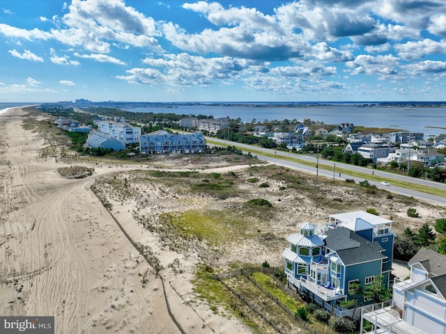 birds eye view of property featuring a water view and a beach view