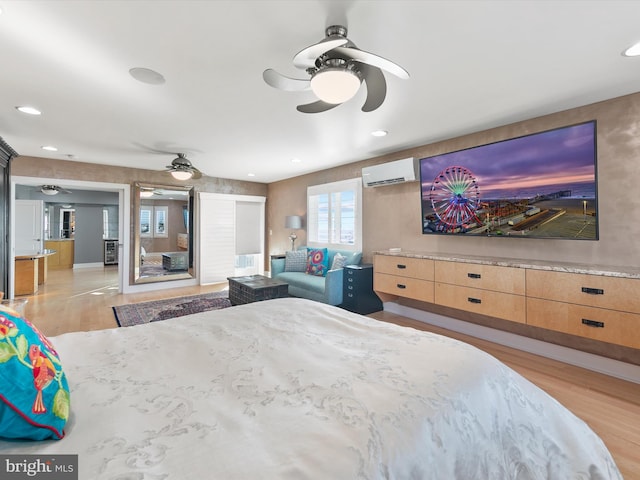 bedroom featuring ceiling fan, light hardwood / wood-style floors, and a wall mounted AC