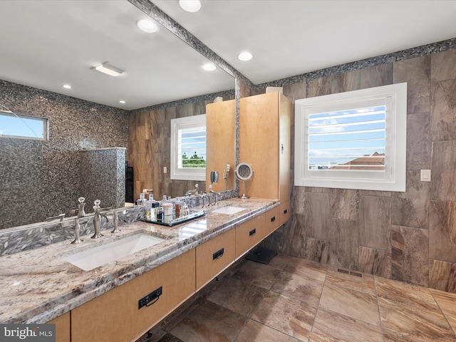 bathroom featuring vanity, tile walls, and a shower