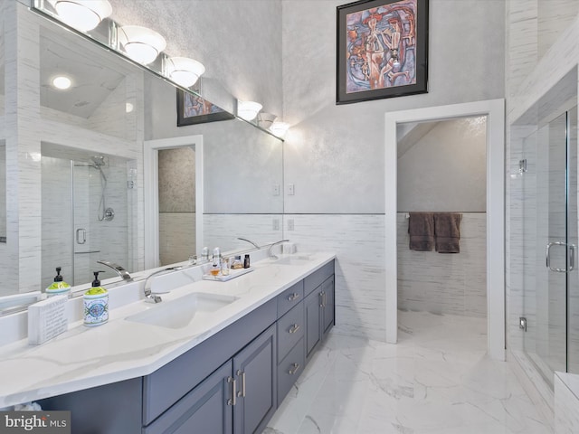 bathroom featuring a shower with shower door, vanity, and tile walls