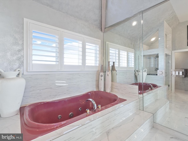 bathroom featuring separate shower and tub, lofted ceiling, and a textured ceiling