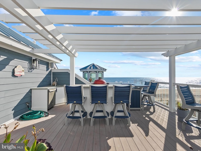 wooden deck with a water view, a pergola, and sink