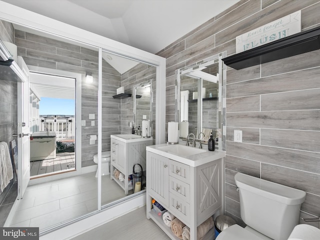 bathroom with lofted ceiling, tile patterned floors, vanity, and toilet