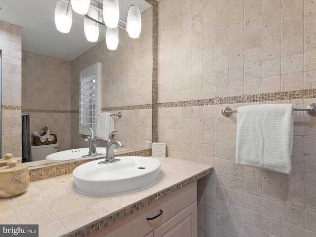 bathroom featuring vanity, tile walls, and toilet