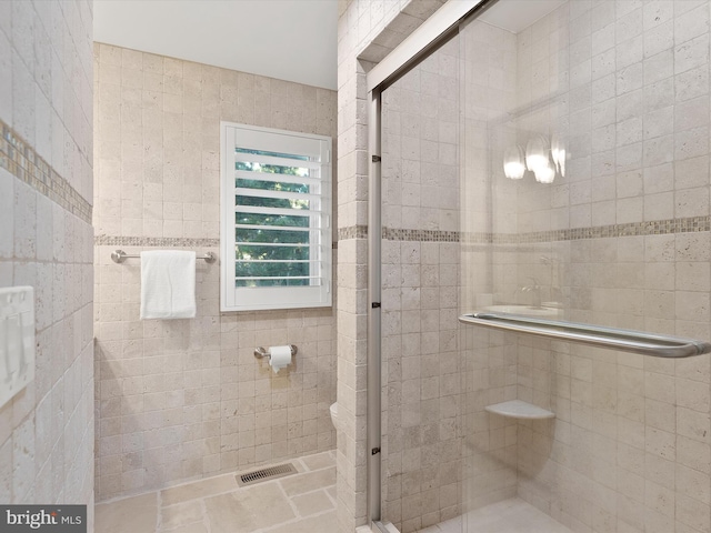 bathroom with walk in shower and tile walls