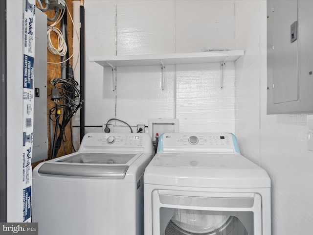 laundry room with electric panel and washer and clothes dryer