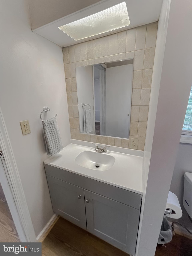 bathroom with vanity, wood-type flooring, and toilet