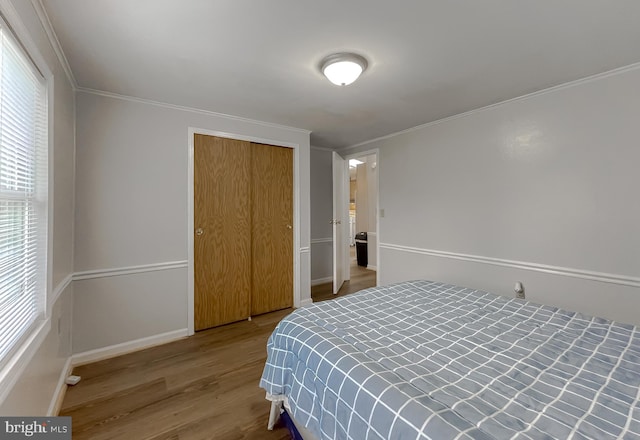 bedroom featuring a closet, ornamental molding, and wood-type flooring