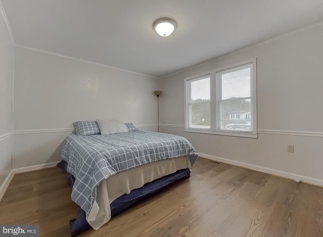 bedroom featuring crown molding and hardwood / wood-style flooring