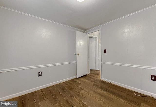 unfurnished room featuring ornamental molding and wood-type flooring