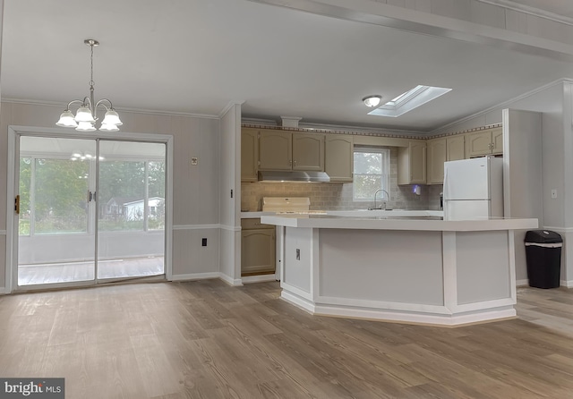 kitchen featuring a kitchen island, light hardwood / wood-style flooring, pendant lighting, and white refrigerator