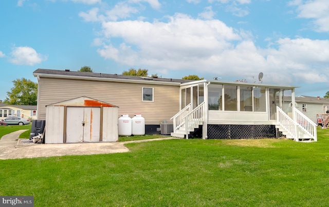 back of property with a yard, a sunroom, cooling unit, and a storage shed