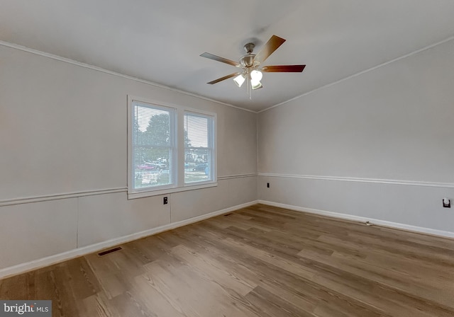 empty room featuring ceiling fan, ornamental molding, and light wood-type flooring