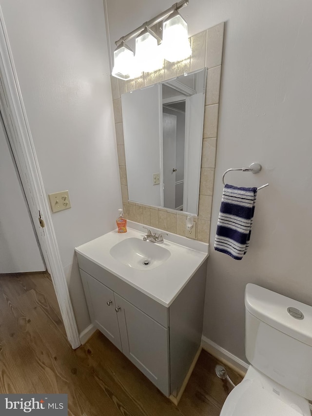 bathroom with vanity, toilet, and hardwood / wood-style flooring