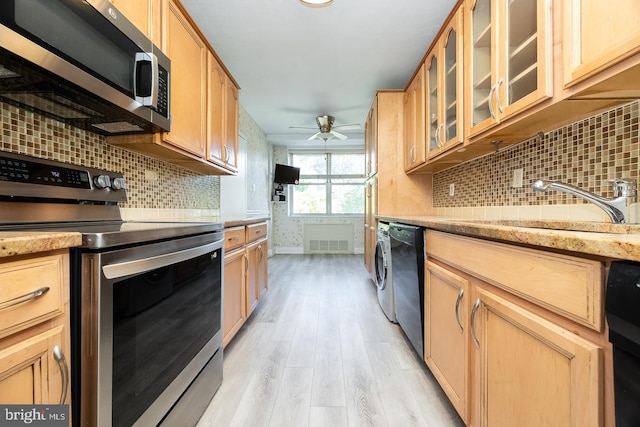 kitchen with ceiling fan, sink, tasteful backsplash, appliances with stainless steel finishes, and light hardwood / wood-style floors