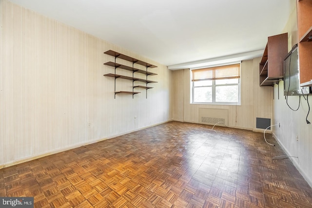 spare room featuring dark parquet flooring